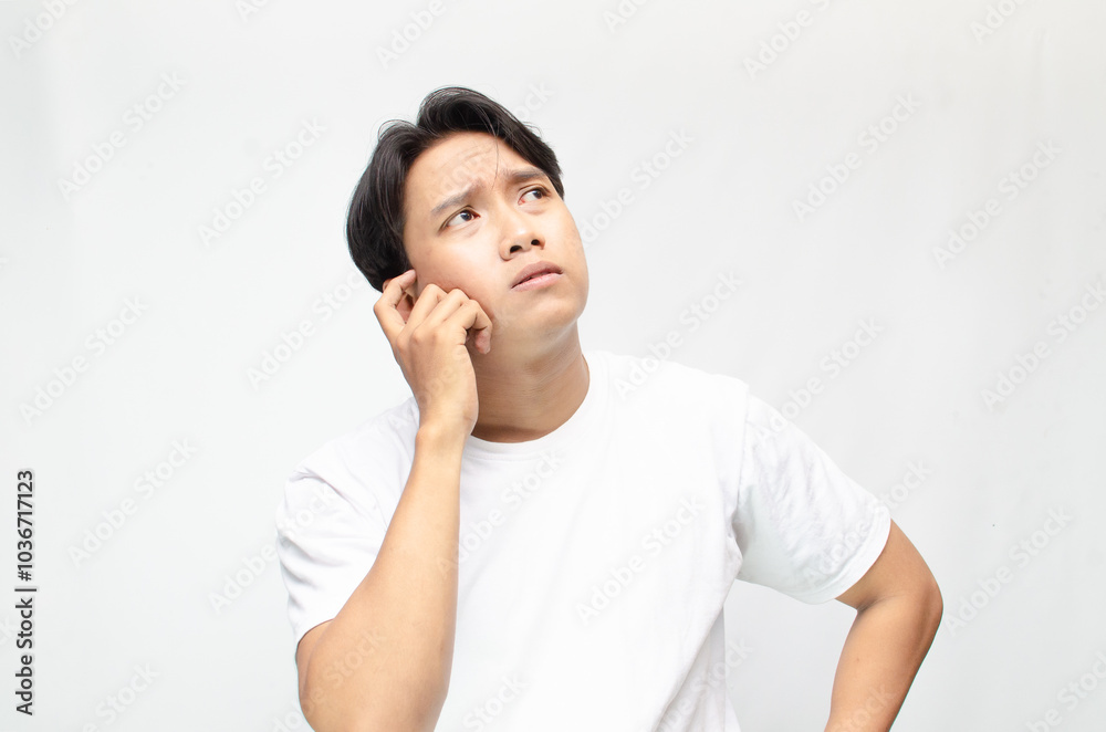 Thoughtful asian man thinking and wondering with hand touching skin as thinking gesture. Thoughtful confused asian man thinking and wondering to choose something. man feeling uncertain and unsure. Thoughtful asian man thinking and wondering with hand touching skin as thinking gesture. Thoughtful confused asian man thinking and wondering to choose something. man feeling uncertain and unsure.
