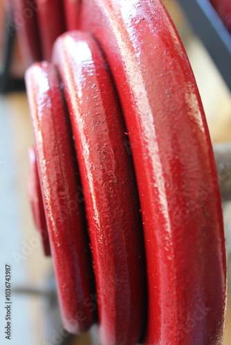 A close up of some red and teal weightlifting dumbells on a rack. 