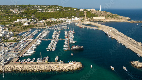 Aerial view of the Leuca lighthouse on the top of Punta Meliso. This is located in Santa Maria di Leuca in Salento, Puglia, Italy. In foreground is the touristic port of the city. photo