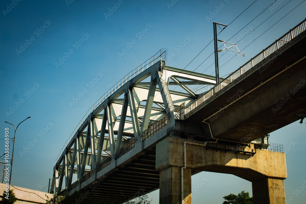 Obraz premium Whoosh High-Speed Rail Bridge Glides Over Indonesian Landscape on a Sunny Day