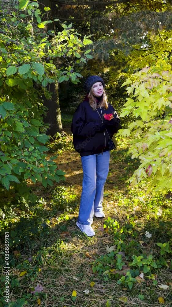 Woman Holding Autumn Leaves in a Sunlit Forest, Smiling in Warm Light Woman Holding Autumn Leaves in a Sunlit Forest, Smiling in Warm Light