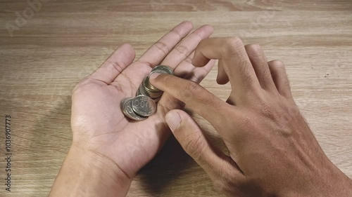 Close-up of a man counting coins in his palm. Financial problems, crisis, or poverty concept.