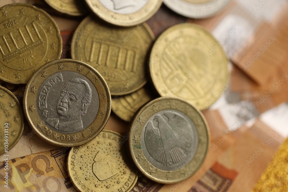 Many cent coins of euro currency lies on many fifty euro bills banknotes