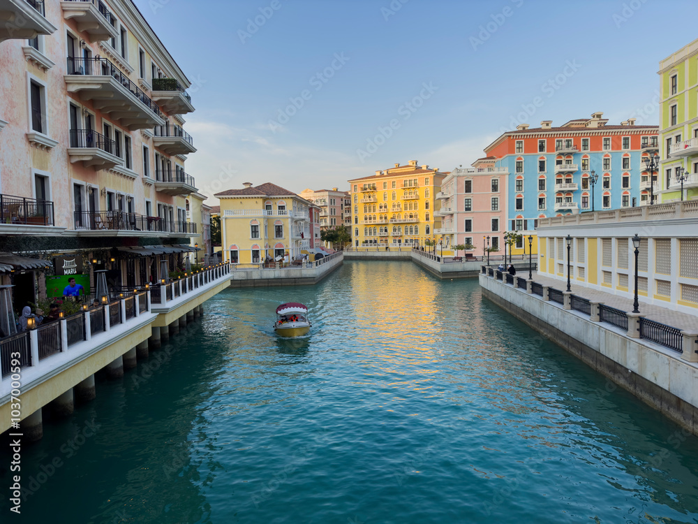 Naklejka premium Qanat Quartier on The Pearl Island in Qatar, which is characterized by brightly colored buildings, a lake in the middle, restaurants and shops, is one of the beautiful . Doha Qatar