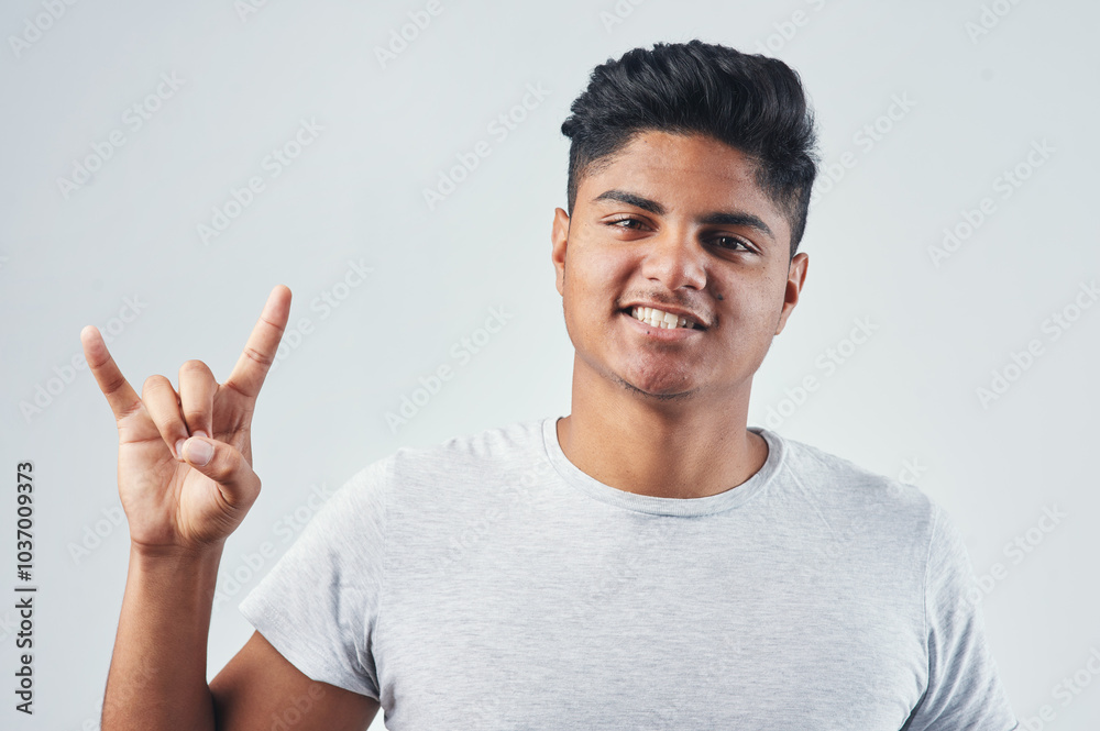 Studio, asian man and portrait with sign for horn, rock gesture and silly expression with crazy feeling. Male person, rocker and ready with emoji symbol for concert, punk icon and white background Studio, asian man and portrait with sign for horn, rock gesture and silly expression with crazy feeling. Male person, rocker and ready with emoji symbol for concert, punk icon and white background