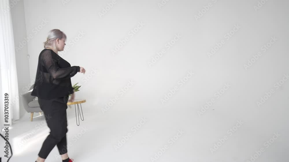 A woman gracefully dancing in an elegant manner within a stylish studio wearing a chic outfit A woman gracefully dancing in an elegant manner within a stylish studio wearing a chic outfit