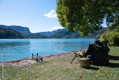 Two fishing rods and a foldable chair at Lake Bled in Slovenia. With ducks. photo