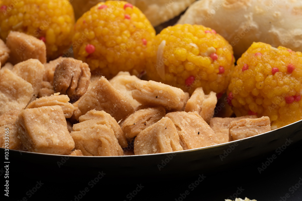 Indian sweets in a plate includes anarsa, shakkarpara morichoor Bundi Laddu, Gujiya or Karanji for diwali celebration Indian sweets in a plate includes anarsa, shakkarpara morichoor Bundi Laddu, Gujiya or Karanji for diwali celebration