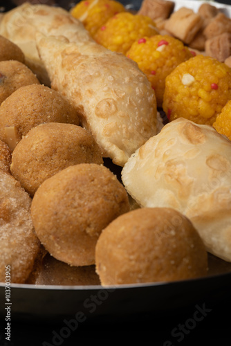 Indian sweets in a plate includes anarsa, shakkarpara morichoor  Bundi Laddu, Gujiya or Karanji for diwali celebration photo