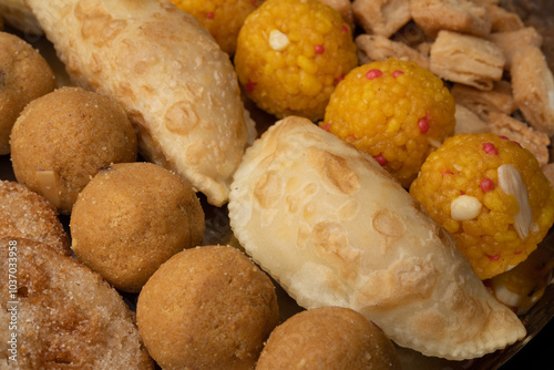 Indian sweets in a plate includes anarsa, shakkarpara morichoor  Bundi Laddu, Gujiya or Karanji for diwali celebration photo