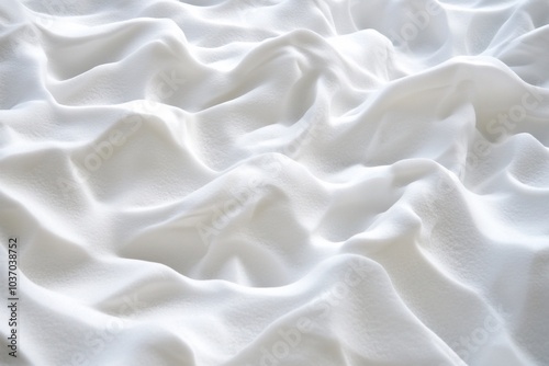 A close-up view of soft, white fabric with gentle waves and folds.