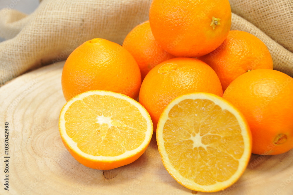 Oranges entières et coupées sur rondin et toile de jute Oranges entières et coupées sur rondin et toile de jute