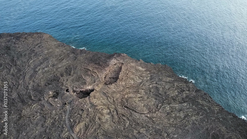 Solidified lava flow meeting the ocean on volcanic coastline