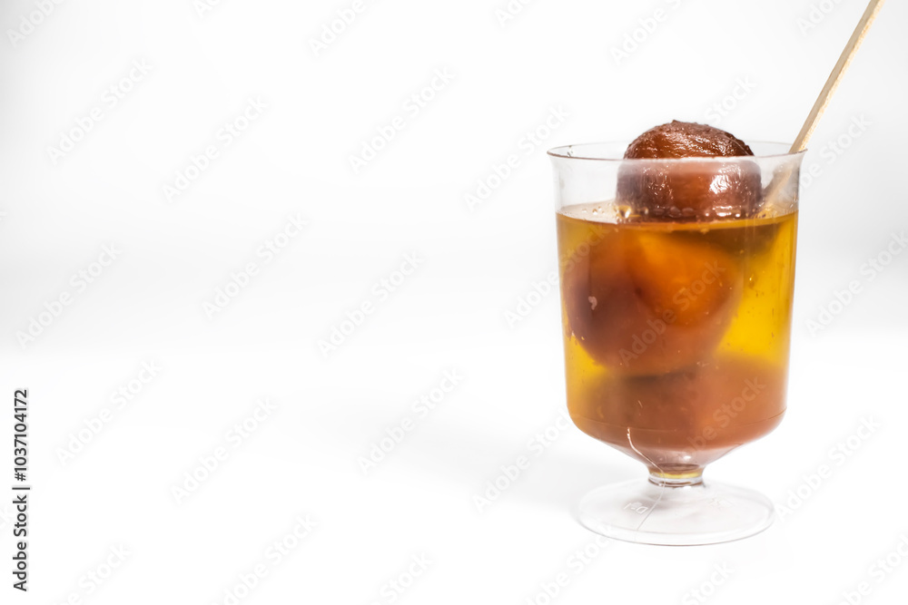Gulab jamun in sugar syrup in a transparent glass cup with a wooden spoon Gulab jamun in sugar syrup in a transparent glass cup with a wooden spoon