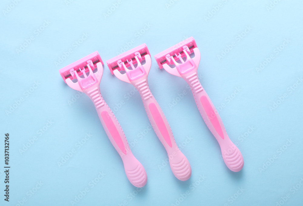 Pink razors on a blue background. Top view Pink razors on a blue background. Top view
