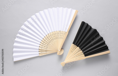 Traditional black and white Asian hand fans on gray background photo