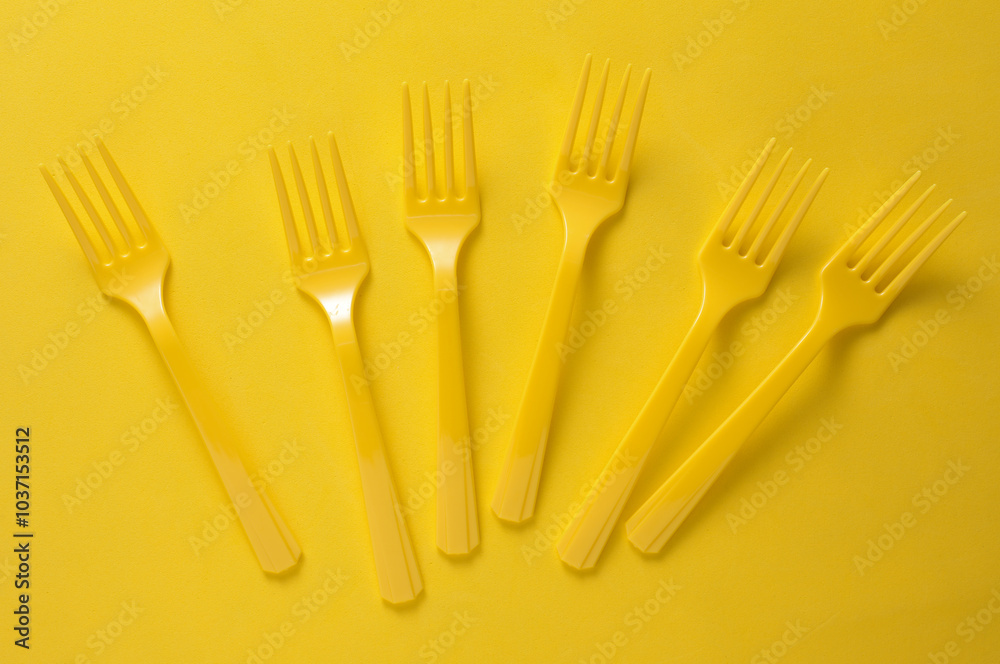 Set of plastic forks on yellow background Set of plastic forks on yellow background