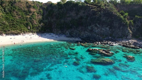 4K Aerial drone video of one of the most beautiful beaches in the world with turquoise clear blue water and white sand with big rocks on a sunny summer day. Marinella di Zambrone Paradiso Tropea Italy