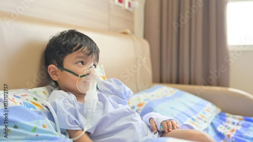 Boy 4 years old , inhale medication by inhalation mask to cure Respiratory Syncytial Virus (RSV) on hospital bed. Admitted patient boy inhalation therapy.