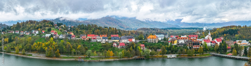 Obraz premium Croatia, Fuzine. Panorama view of a line of bright houses on a mountain slope near the shore of a lake in autumn. Picturesque village 