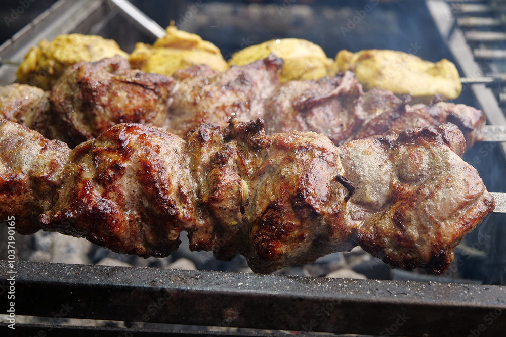 Delicious hot kebabs. Meat are cooked on coals in barbecue, rotates on skewers Delicious hot kebabs. Meat are cooked on coals in barbecue, rotates on skewers