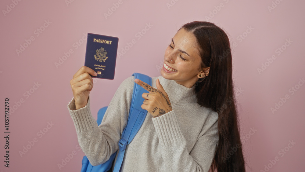 Hispanic woman pointing at a united states passport over an isolated pink background with a cheerful expression. Hispanic woman pointing at a united states passport over an isolated pink background with a cheerful expression.