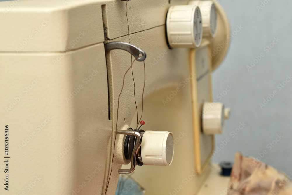 The picture shows a sewing machine with control knobs in close-up. The picture shows a sewing machine with control knobs in close-up.