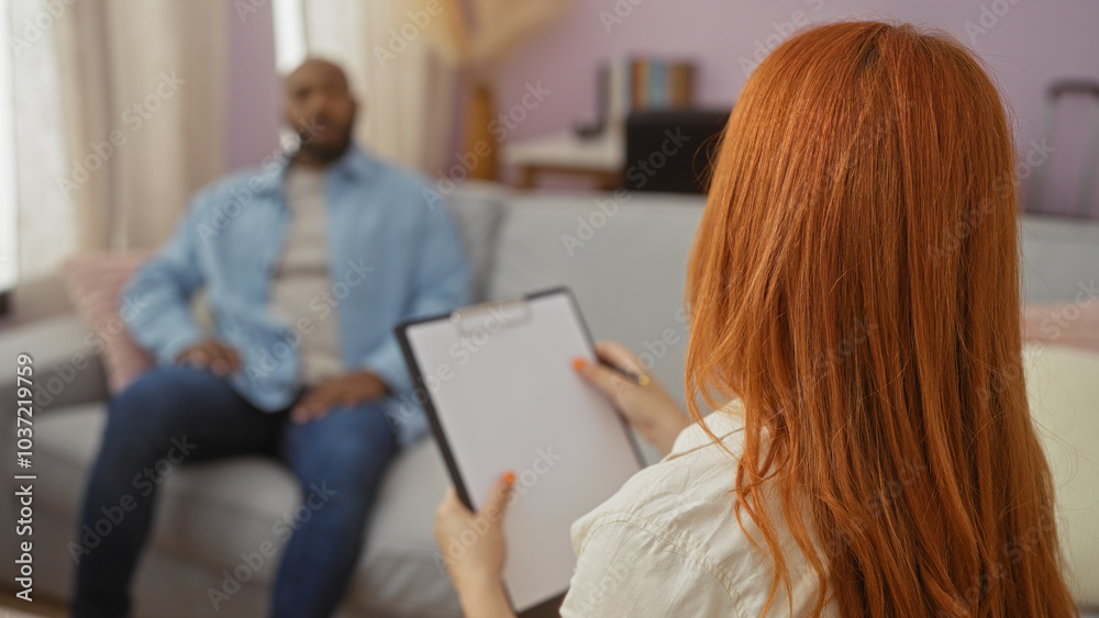 Woman talking to man during therapy session in home living room showing interracial relationship and family love Woman talking to man during therapy session in home living room showing interracial relationship and family love