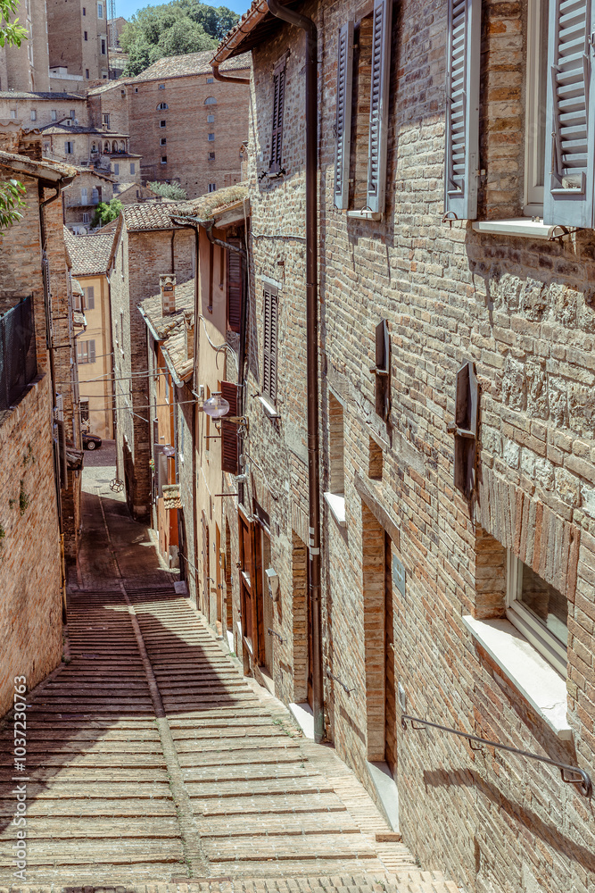 The historic streets of Urbino, a medieval town in Marche, Italy, with charming stone buildings and steep, winding staircases. Urbino, Marche, Italy