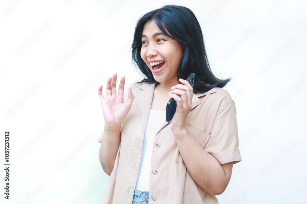 shocked asian woman holding smartphone looks amazed wearing casual clothes isolated on white background shocked asian woman holding smartphone looks amazed wearing casual clothes isolated on white background