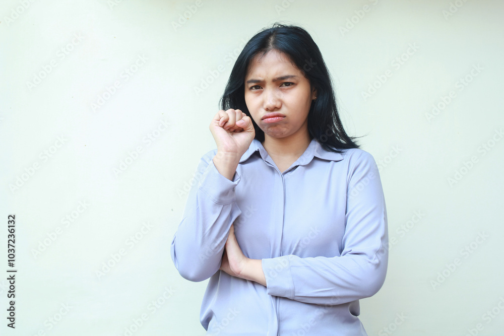 displeased offended asian young woman employee crying with fist pump and folded arm looking to camera sadly wear formal purple shirt standing over isolated white background displeased offended asian young woman employee crying with fist pump and folded arm looking to camera sadly wear formal purple shirt standing over isolated white background