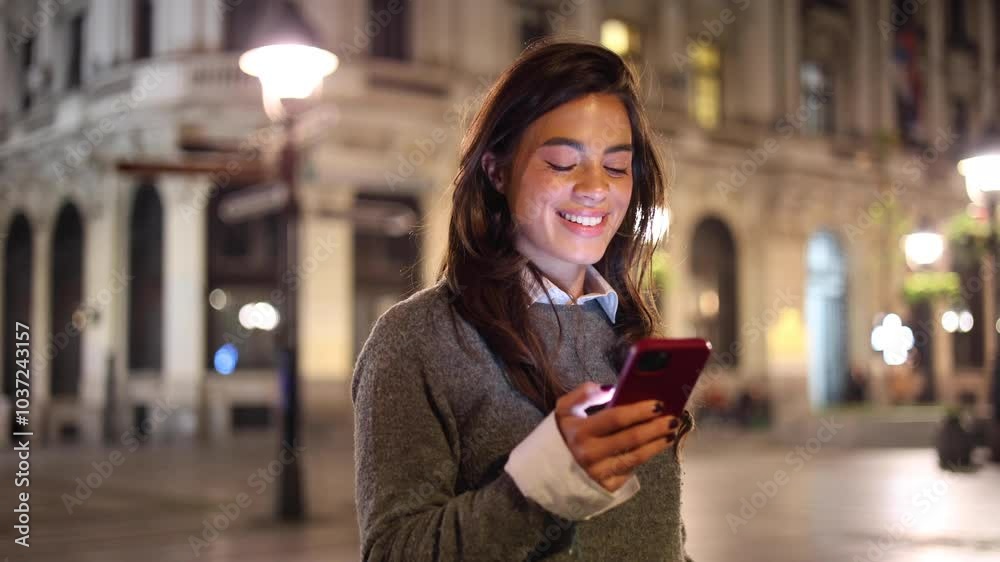 Smiling young woman enjoying in the city at night and texting Smiling young woman enjoying in the city at night and texting