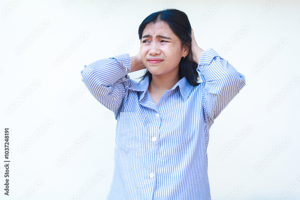 stress asian woman wearing blue striped shirt holding her hair with frowing face standing over isolated white background, look away stress asian woman wearing blue striped shirt holding her hair with frowing face standing over isolated white background, look away