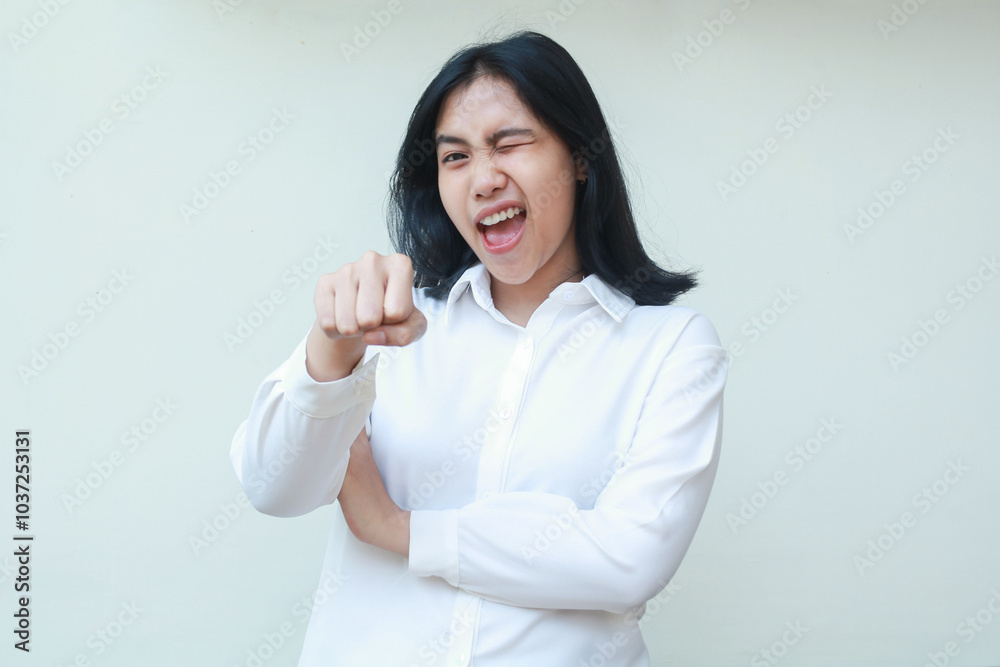 carefree ecstatic asian young business woman raising fist pump towards camera with arms folded wearing white suit shirt, screaming excited flirting and blink eye, standing over isolated background carefree ecstatic asian young business woman raising fist pump towards camera with arms folded wearing white suit shirt, screaming excited flirting and blink eye, standing over isolated background
