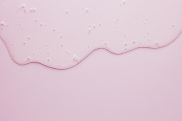 Liquid cosmetic minimal pink background, flowing gel texture, dripping jelly cream or face serum beauty product