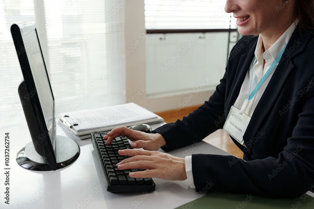 Businesswoman typing on keyboard and working online while sitting at her workplace in office Businesswoman typing on keyboard and working online while sitting at her workplace in office