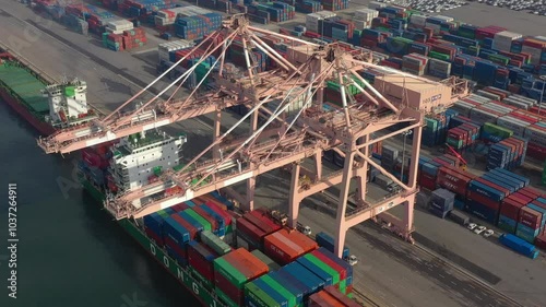 ASAN, SOUTH KOREA - OCTOBER 16, 2024: Container cranes operate at busy port unloading cargo from ships in Asan's bustling shipping hub