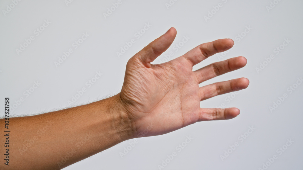 Man's hand with brown skin extended against a plain light gray background, showing clear palm lines and slightly spread fingers in a close-up view Man's hand with brown skin extended against a plain light gray background, showing clear palm lines and slightly spread fingers in a close-up view