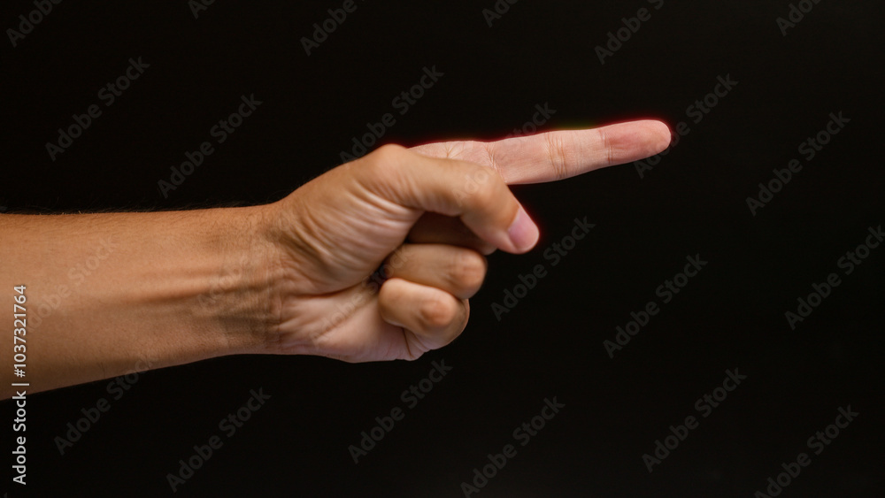 Man pointing finger gesture with hand on dark background in a close-up color photo Man pointing finger gesture with hand on dark background in a close-up color photo