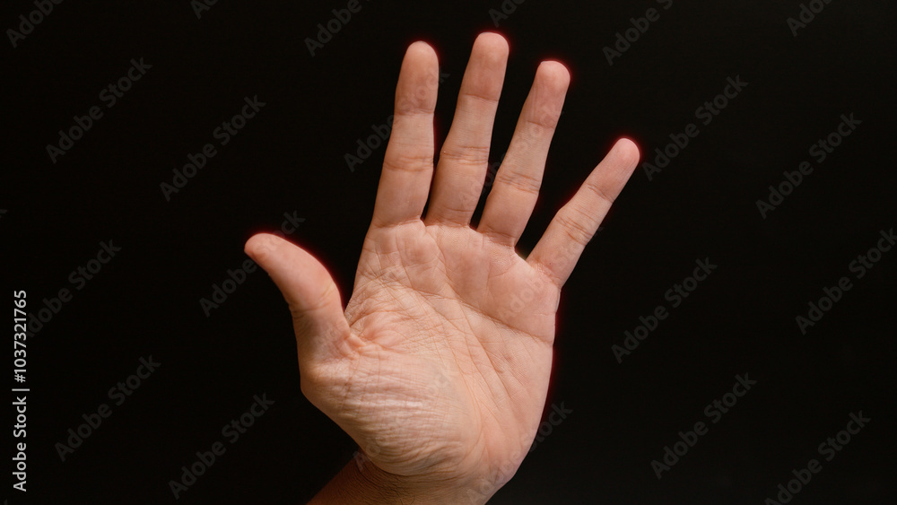 Male hand with an open palm against a black background showing the detailed lines and texture of the skin Male hand with an open palm against a black background showing the detailed lines and texture of the skin