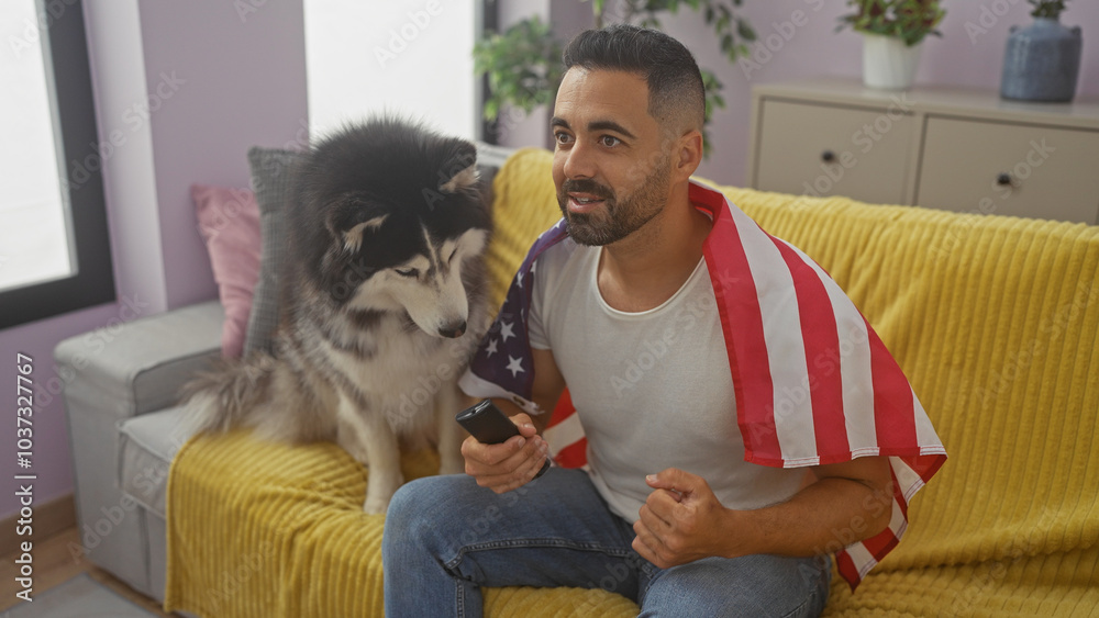 Hispanic man with american flag draped over shoulders enjoys time with husky in living room