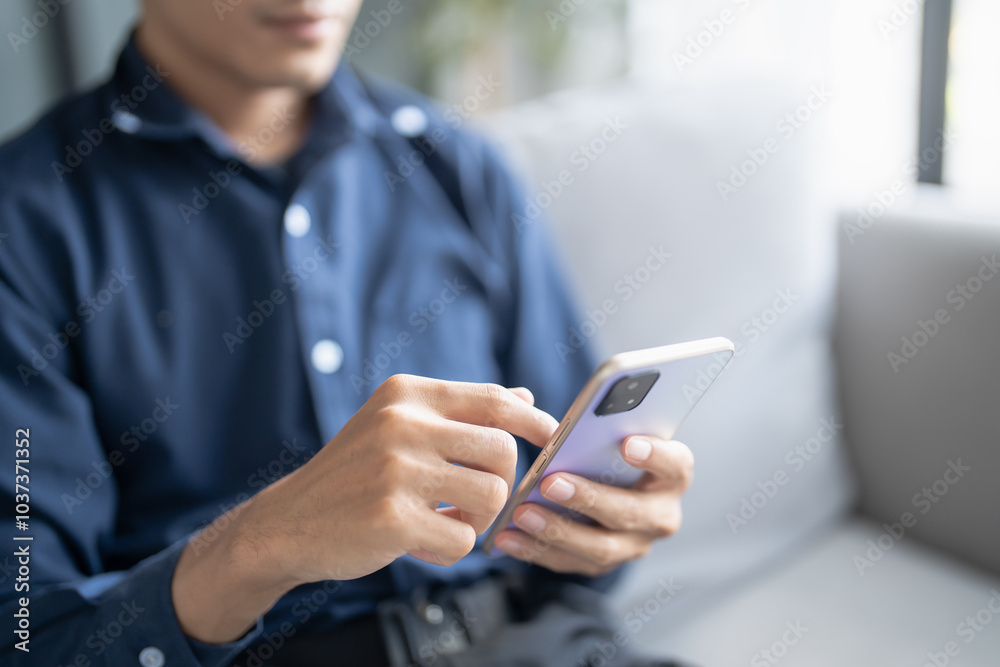 Relaxed young asian man using smart phone spending time checking news social media Relaxed young asian man using smart phone spending time checking news social media