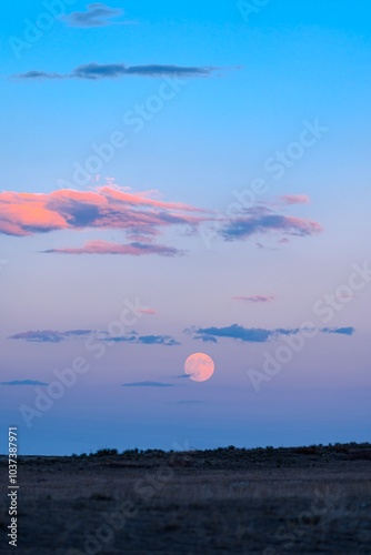 HDR October Supermoon Rise at Sunset with colorful clouds, pink and blue cotton candy sunset at dusk in Wyoming super moon