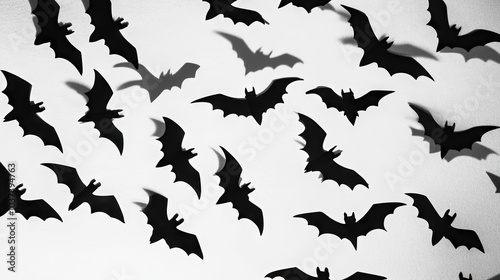 Multiple paper bats on a white background, arranged in a pattern resembling a swarm, casting shadows that add a dramatic Halloween-themed effect --chaos