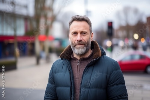 Portrait of a handsome middle aged man with grey beard wearing winter jacket