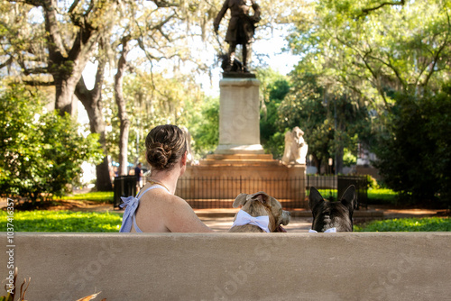 woman and two dogs sitting in front of statue