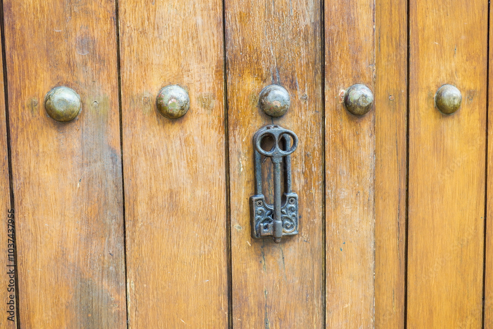 Close up of old Key in wooden door at home, Brown Wood Front Door with Ornate Brass Skeleton Key,copy space.. Close up of old Key in wooden door at home, Brown Wood Front Door with Ornate Brass Skeleton Key,copy space..