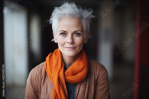 Portrait of a beautiful senior woman with short gray hair and orange scarf