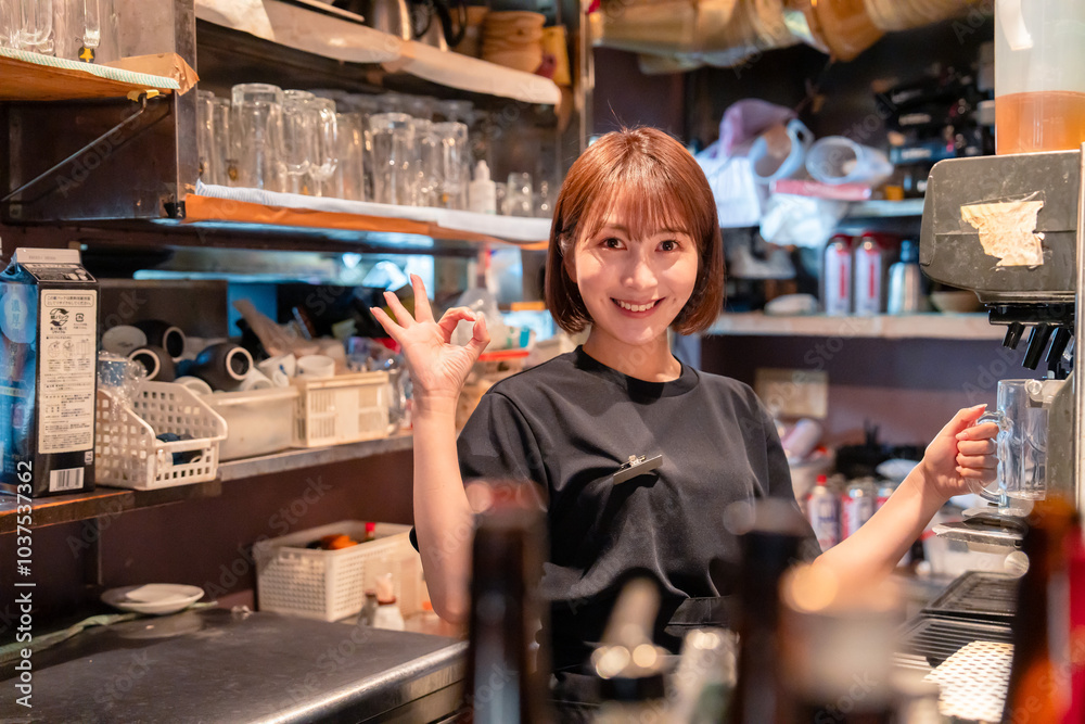 飲食店でビールサーバーを使う女性の店員 飲食店でビールサーバーを使う女性の店員