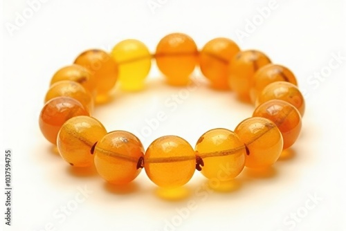 Polished amber bead bracelet in golden and honey tones on white background photo